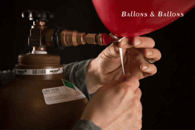 Eine Person bringt einen Draht an einem Ballon in Wien an.