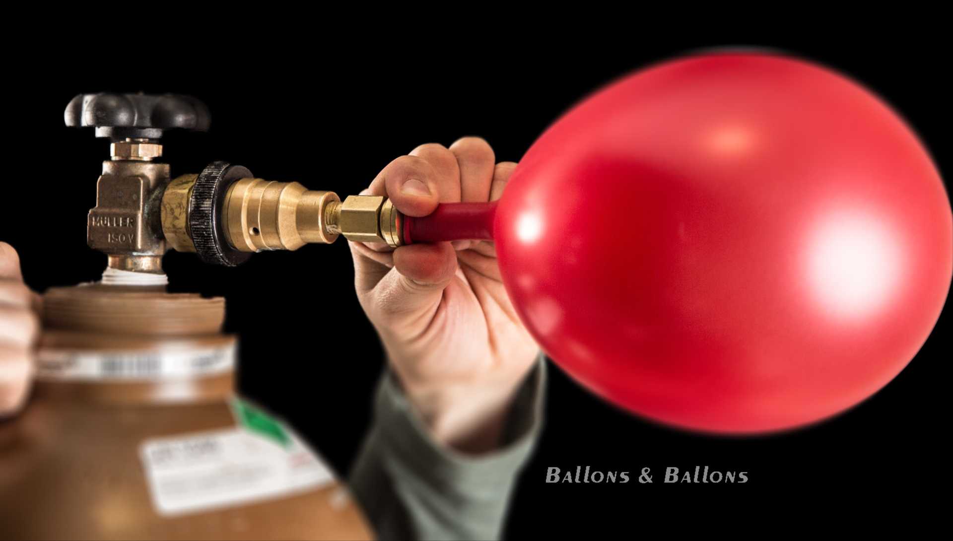 Eine Hand, die einen roten Ballon mit einem weißen Ventil hält.