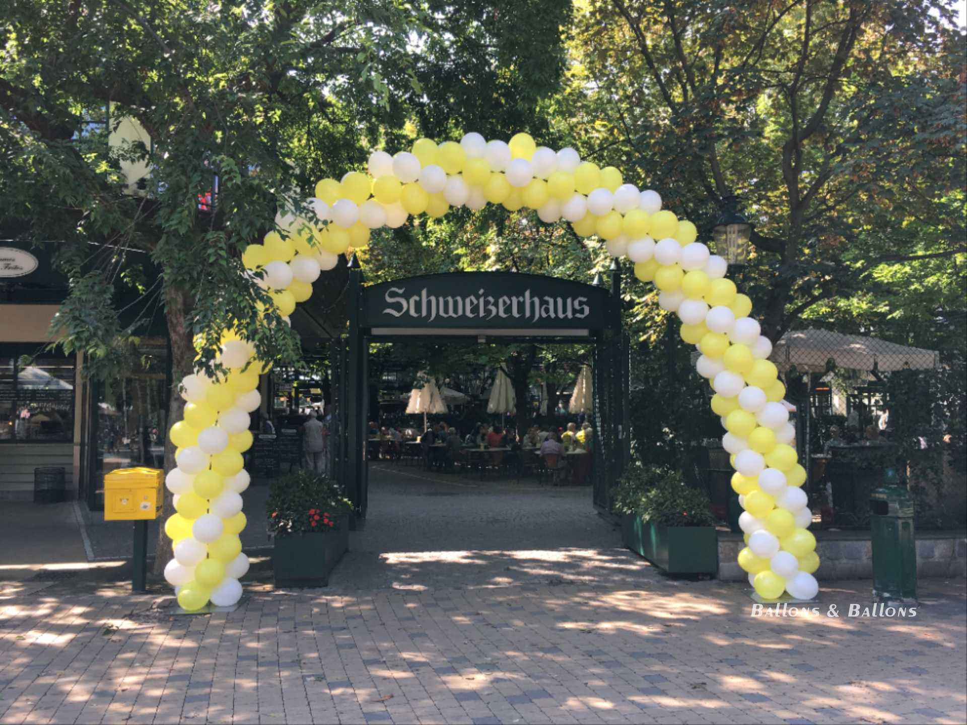 Ein großer gelber und weißer Ballonbogen auf der Straße in Wien