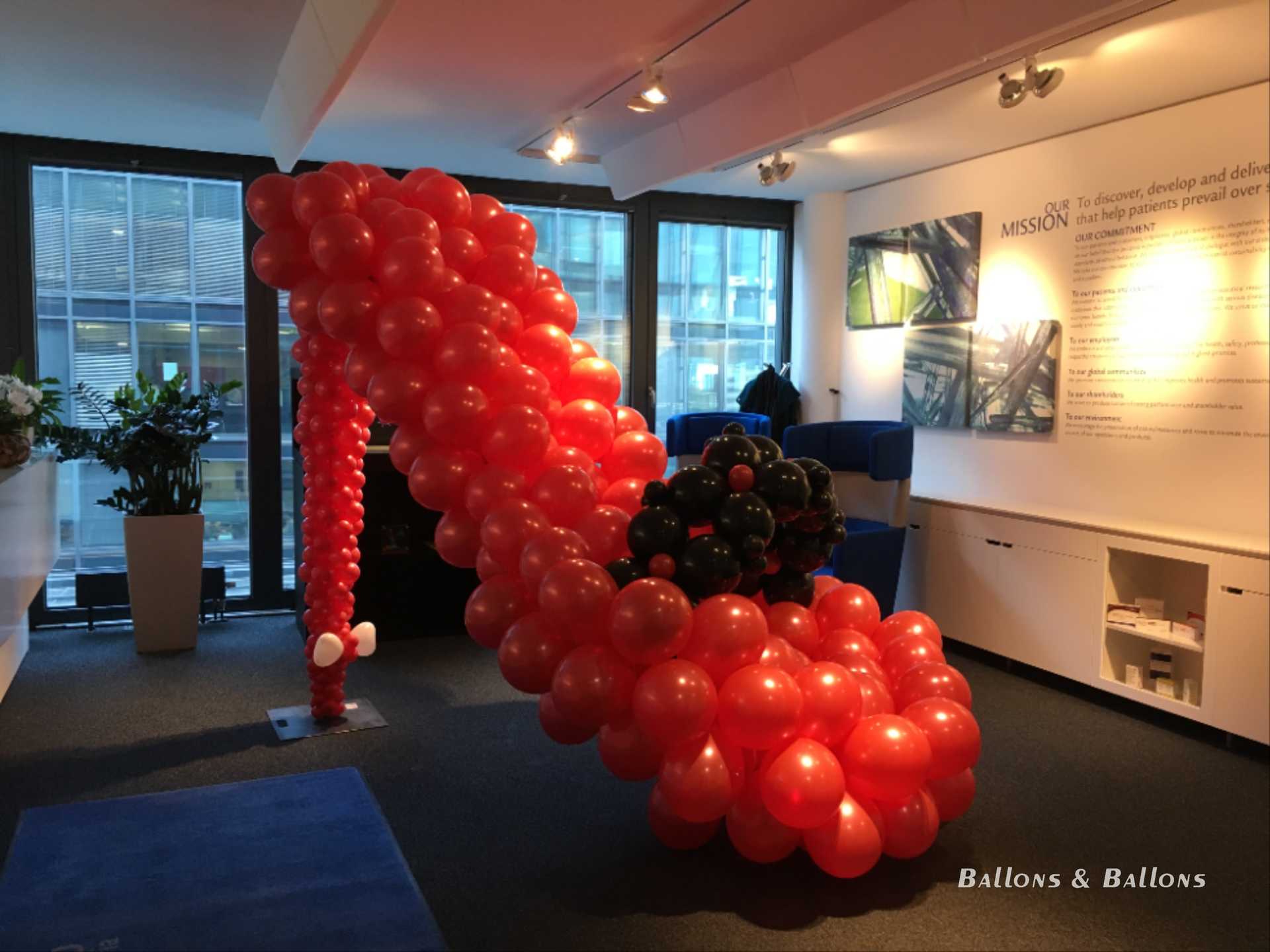 Eine große rote und schwarze Ballonskulptur in einem Museum in Wien.