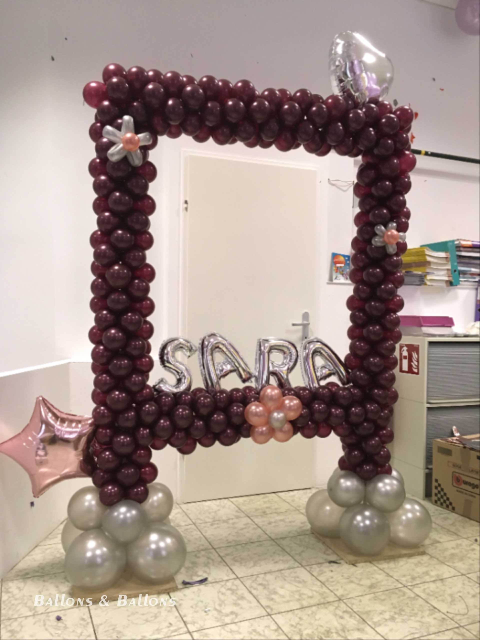 Ein Ballonbogen in Form eines Rahmens mit Luftballons und einer Beschriftung in einem Geschäft in Wien.