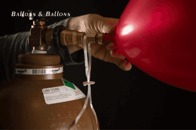 Eine Hand drückt einen roten Ballon auf eine Gasflasche in Wien.