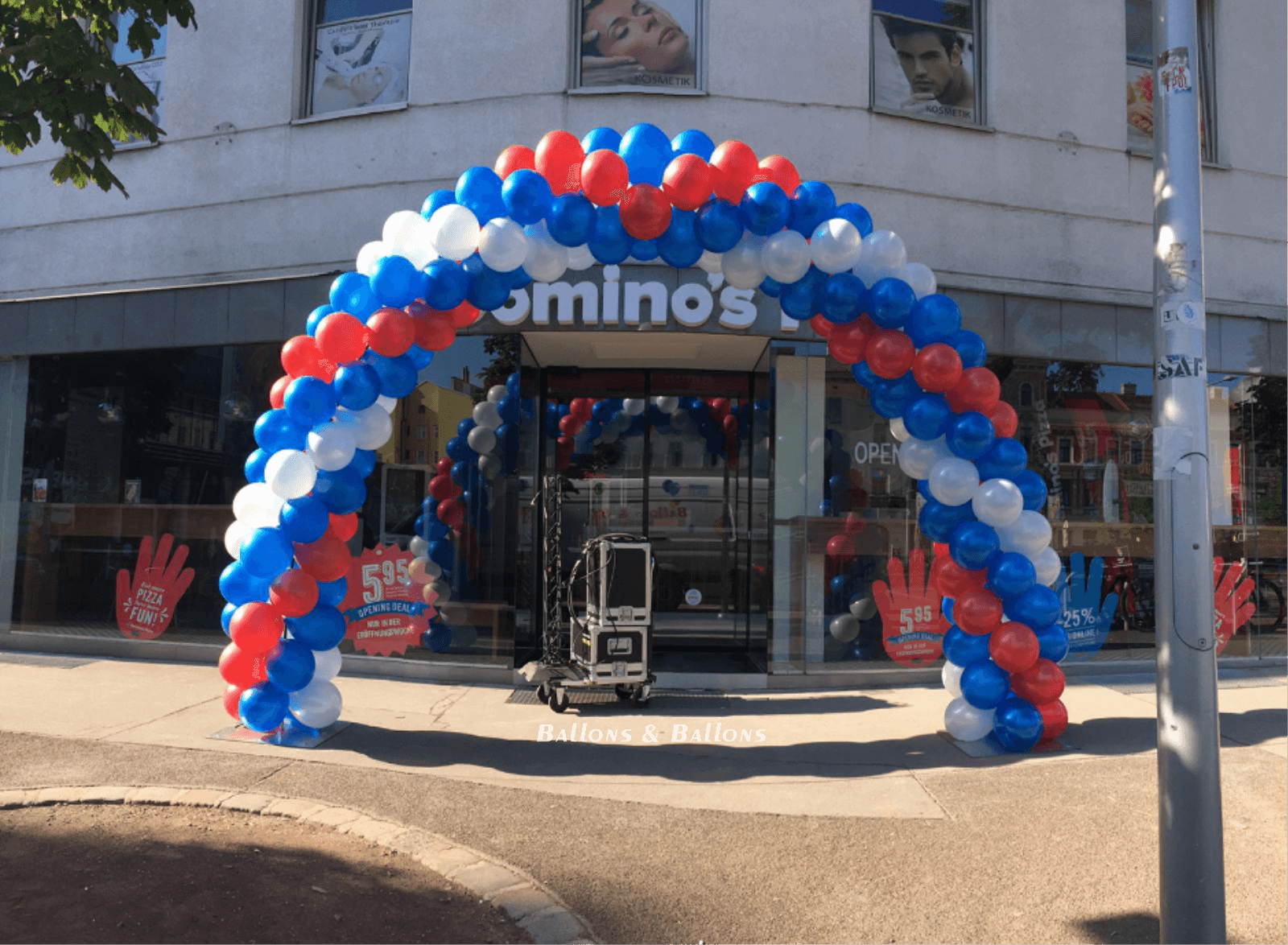Ein großer roter-weiß-blauer Ballonbogen vor einem Geschäft in Wien.