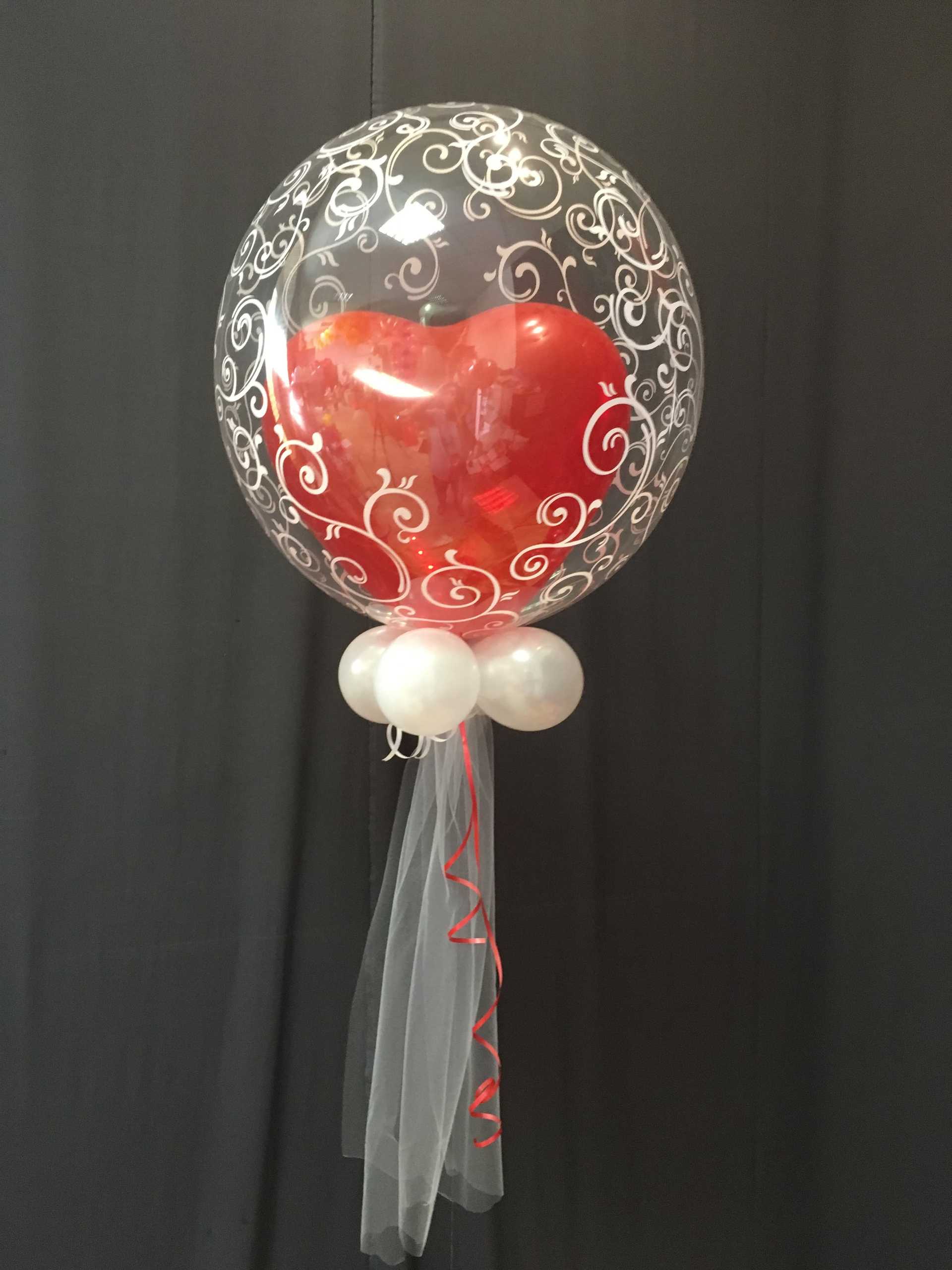 Ein Herzballon hängt an einem schwarzen Band in Wien.